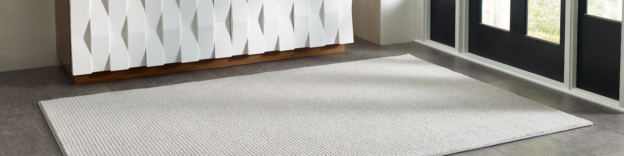 white cabinet on entrance area and a white rug in front of a black door - Shamrock Carpets in Uniontown, PA